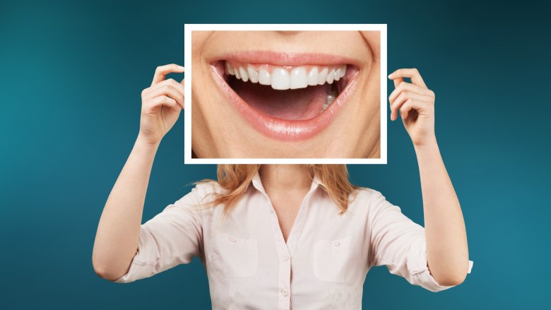 woman holding up picture of mouth to show rare body feature