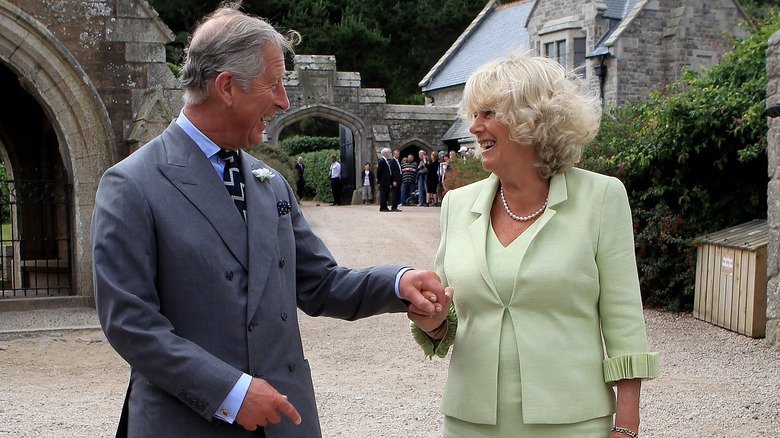 King Charles and Queen Camilla holding hands 