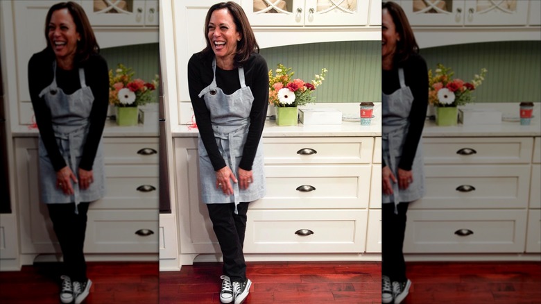 Kamala Harris laughing in cooking apron and sneakers