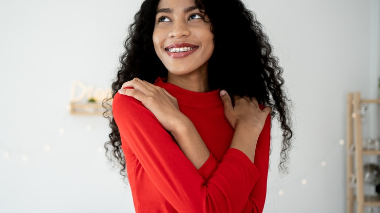 Smiling woman touching her sweater