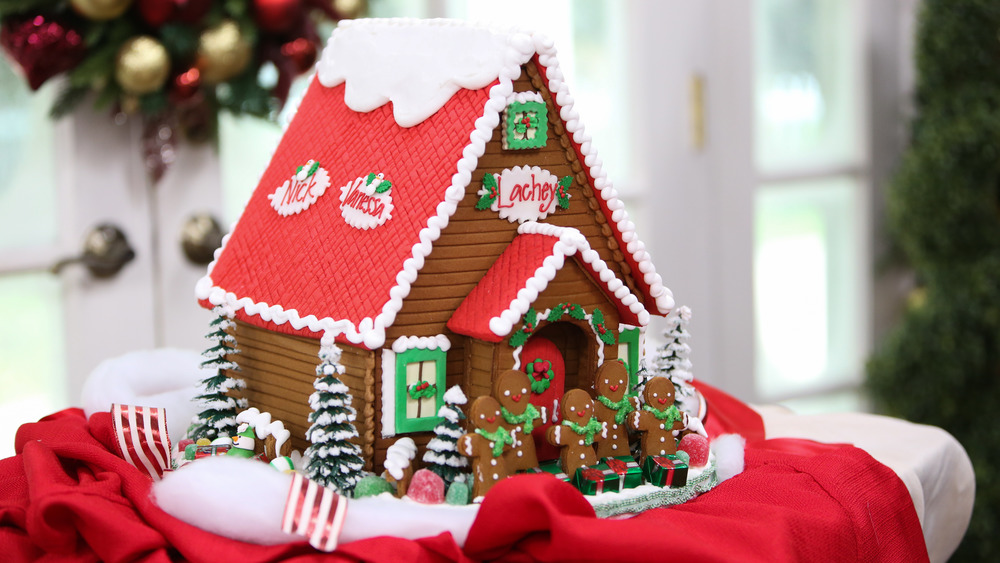 Gingerbread house sitting on a red cloth 