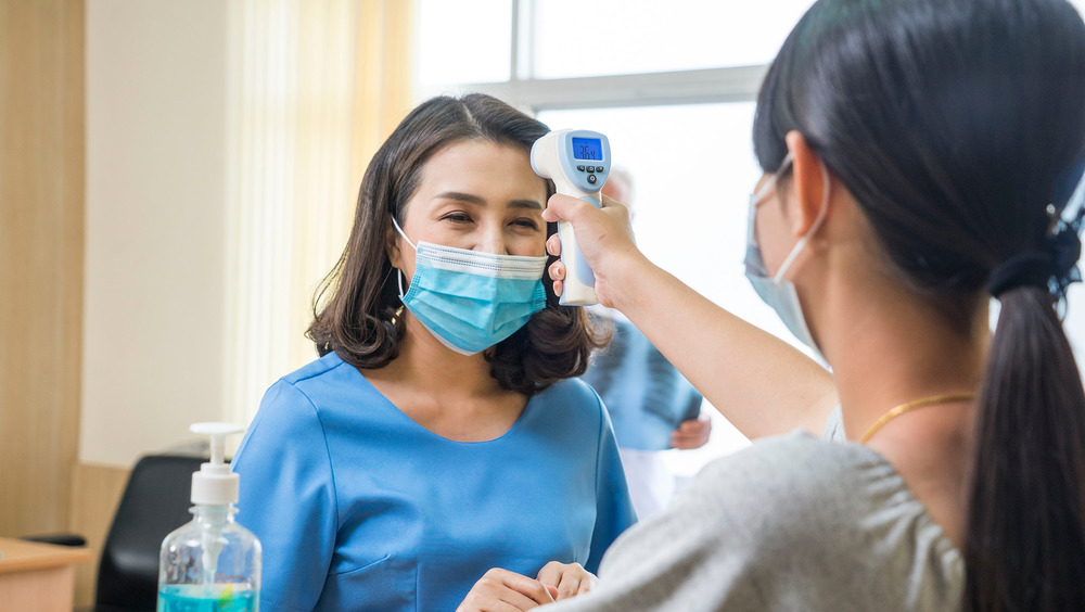 Woman getting temperature checked