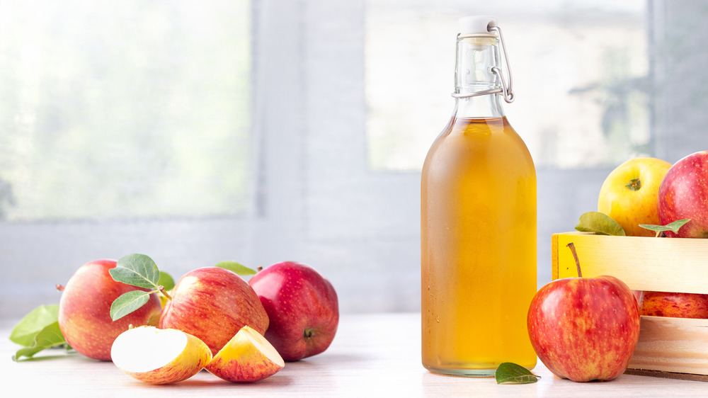 Glass bottle of ACV and apples