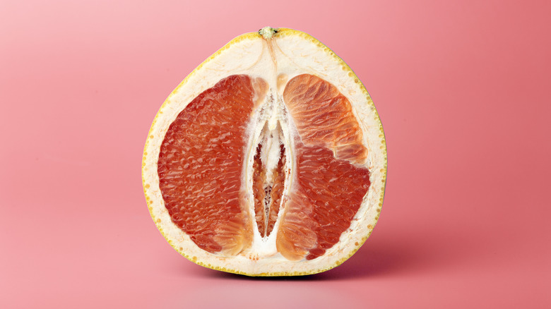 A sliced grapefuit on a pink background.