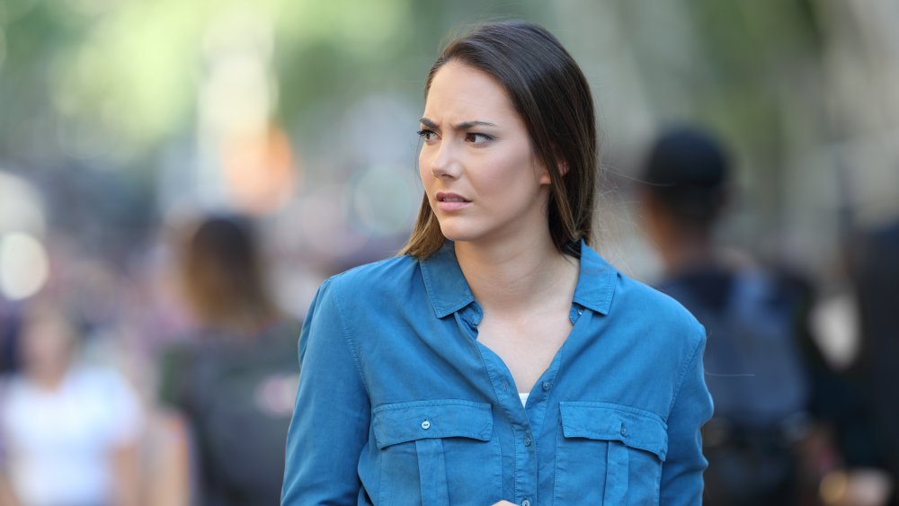 A woman walking outside, slightly anxious