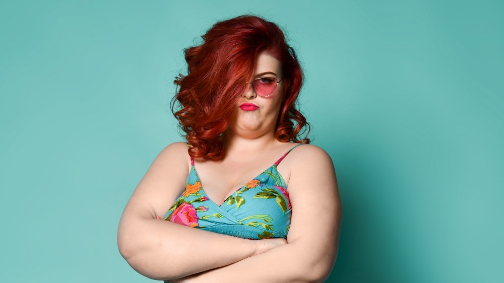 A redheaded woman with her arms crossed