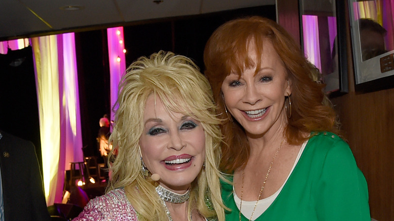 Dolly Parton and Reba McEntire grinning