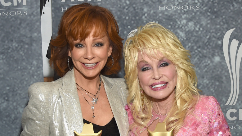 Dolly Parton and Reba McEntire posing together at the 11th ACM Honors in 2017