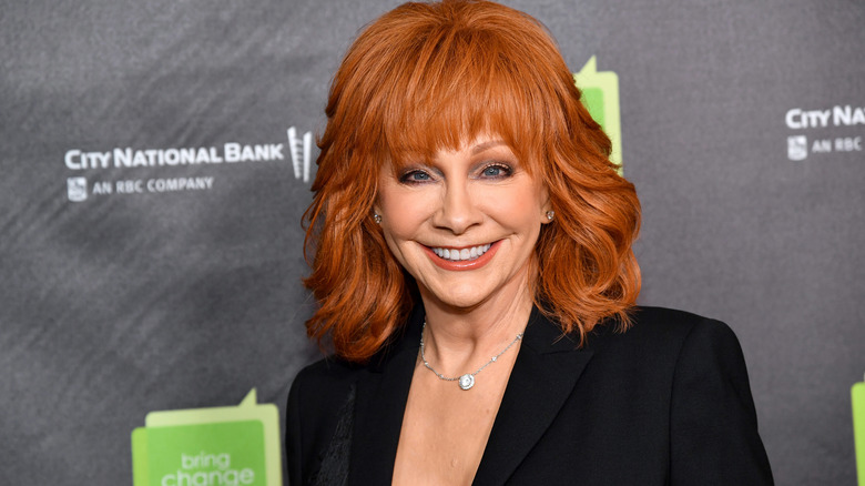 Reba McEntire smiling in a black blazer for an event in support of teen mental health at City Winery in October 2023 in New York City