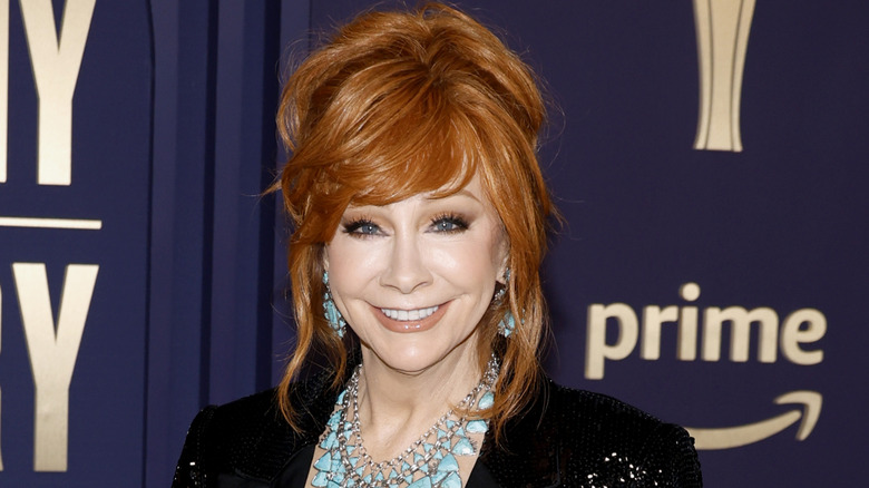 Reba McEntire with her hair up, strands framing her face and a big smile