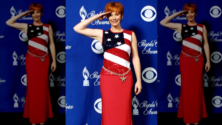 Reba McEntire saluting while wearing an American-flag outfit