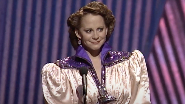 Reba McEntire accepting an award in over-the-top outfit.