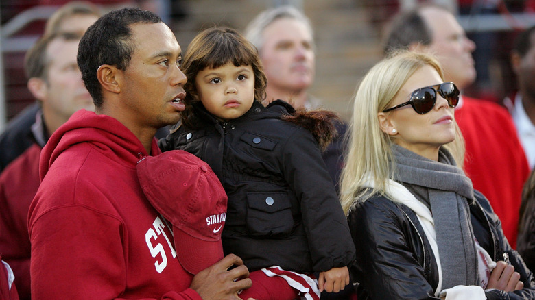 Tiger Woods and Elin Nordegren stand with daughter Sam at a sports game in 2009