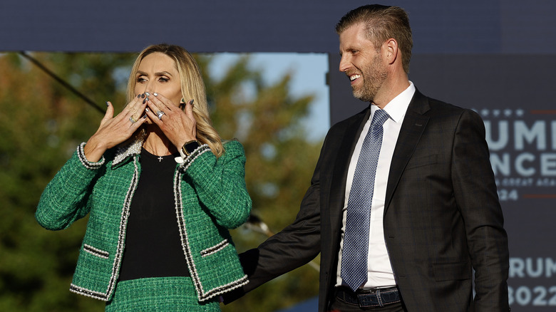 Lara Trump blowing a kiss while Eric Trump smiles beside her