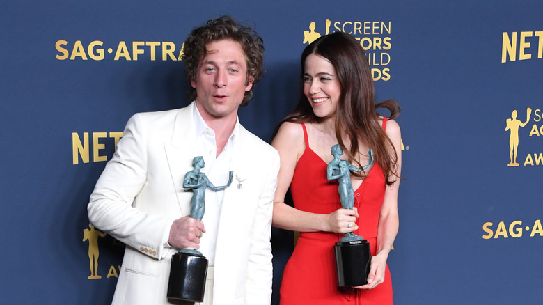 Jeremy Allen White and Molly Gordon laughing together on the red carpet