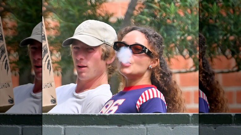 Jeremy Allen White photographed hanging out with Ashley Moore, who is blowing out smoke