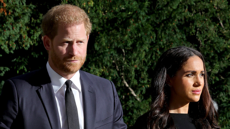 Prince Harry and Meghan Markle looking morbid