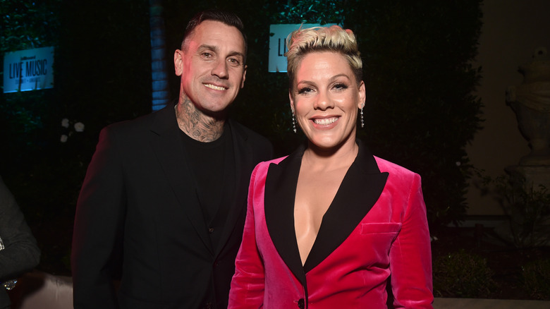 Pink in a red blazer with black lapel Carey Hart in black