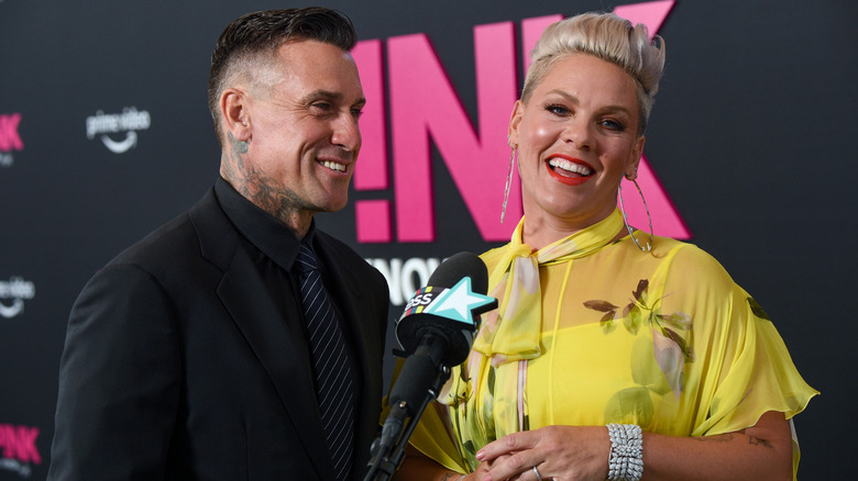 Pink with blonde hair in yellow dress with Carey Hart in black