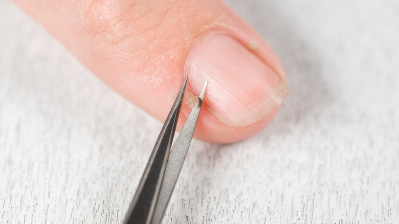 Woman's nail getting cuticles cut