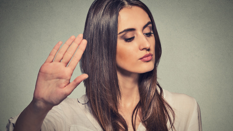 Irritated woman putting hand up