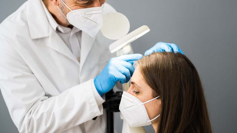 dermatologist examines woman's scalp