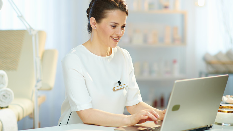 Hairdresser smiling on computer