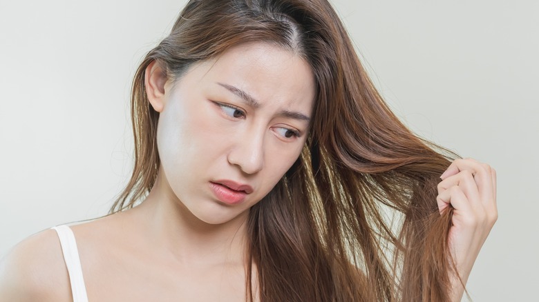 Sad woman looking at hair