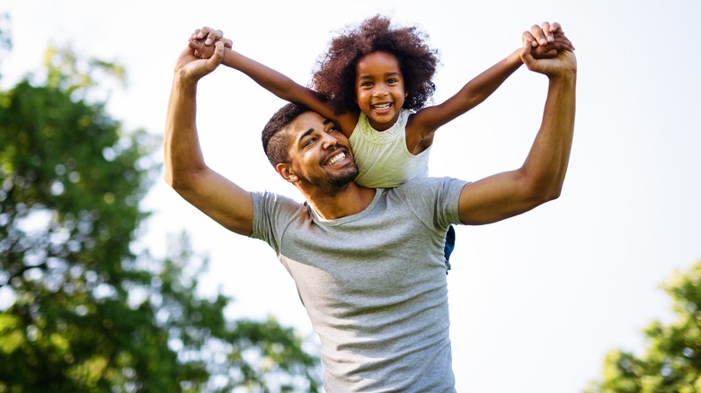 dad giving daughter piggy back ride