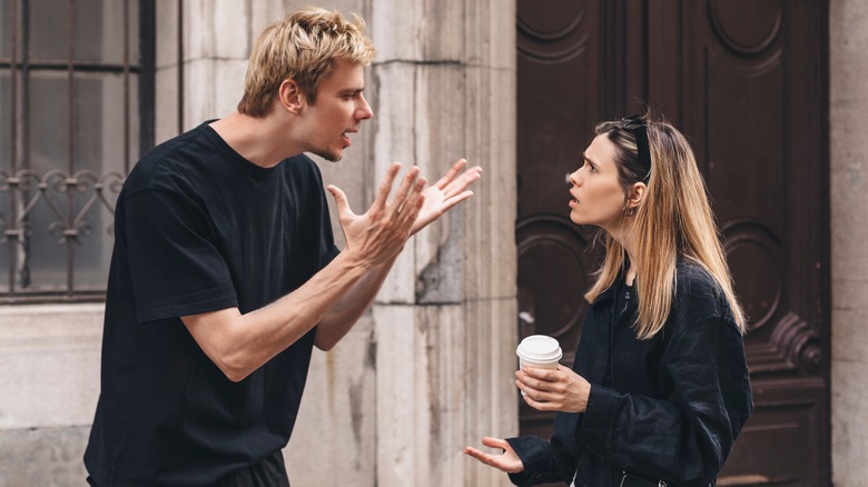 man and woman fighting on the street