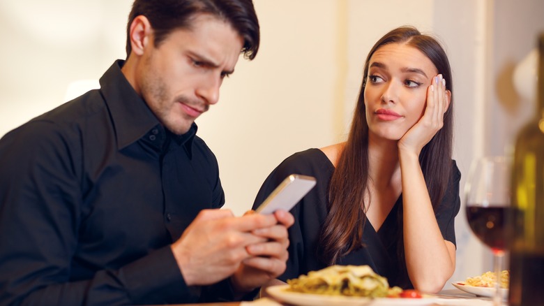 Man on phone during date