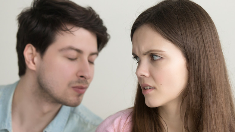 man trying to kiss uninterested woman