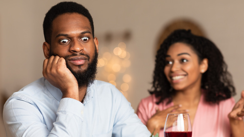 man ignoring woman on date