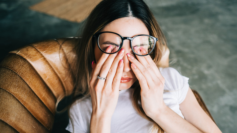 Tired woman rubbing her eyes