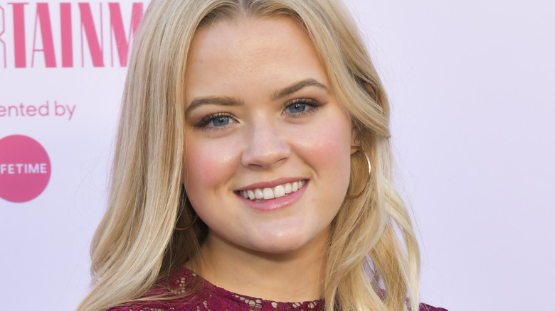 Ava Phillippe smiling against a pink background