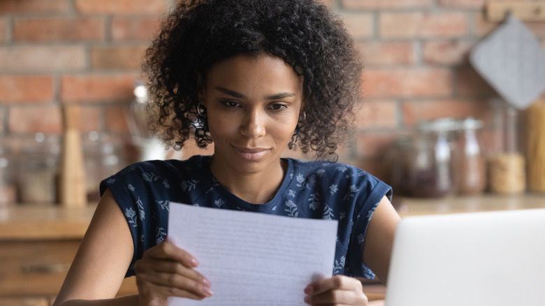 smirking woman looking at letter