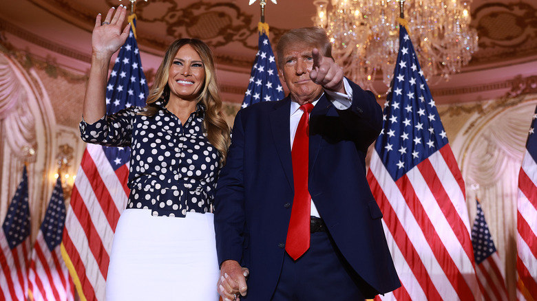 Donald and Melania Trump holding hands and waving