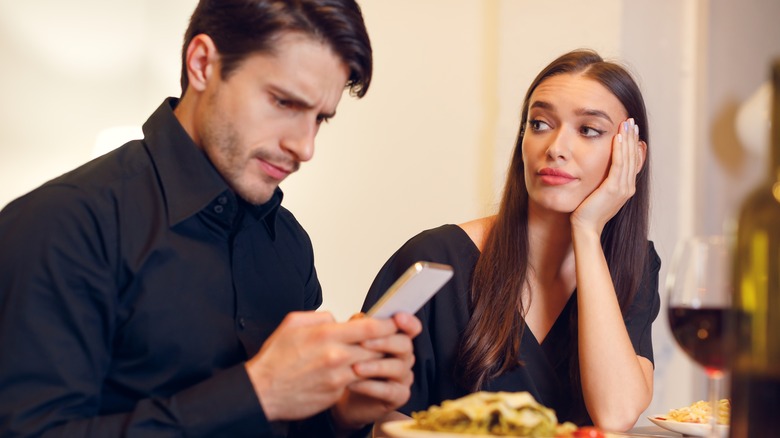 Woman judging a man on his phone 