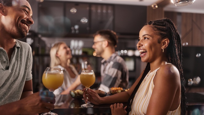 Black couple laughing at the bar