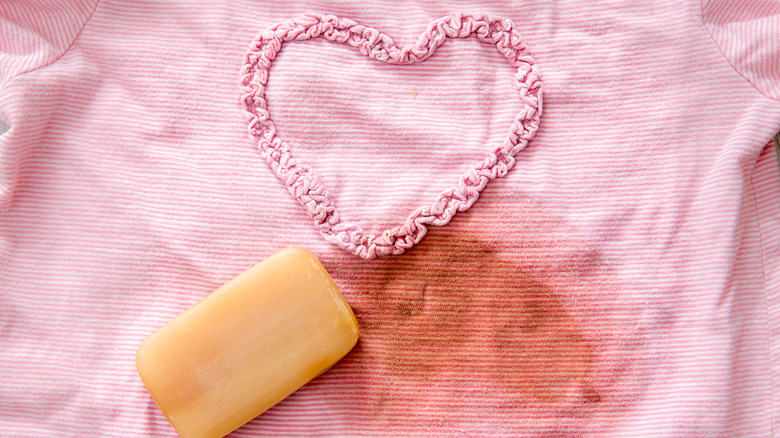 rubbing a stain out of a pink shirt