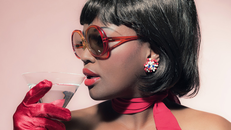 1960s Black woman drinking a cocktail