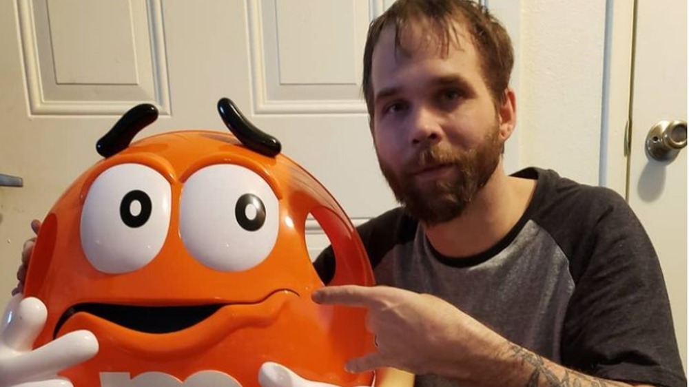 Jeremiah Raber poses with a large orange M&M candy