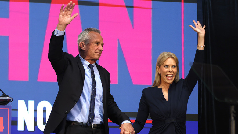 RFK Jr. and Cheryl Hines waving at a crowd