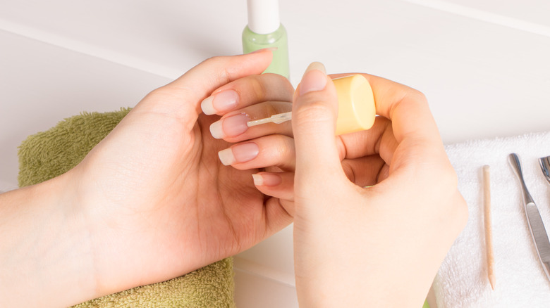 person applying cuticle oil 