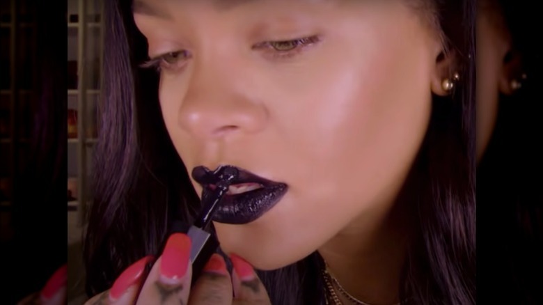 Rihanna applying black lipstick 