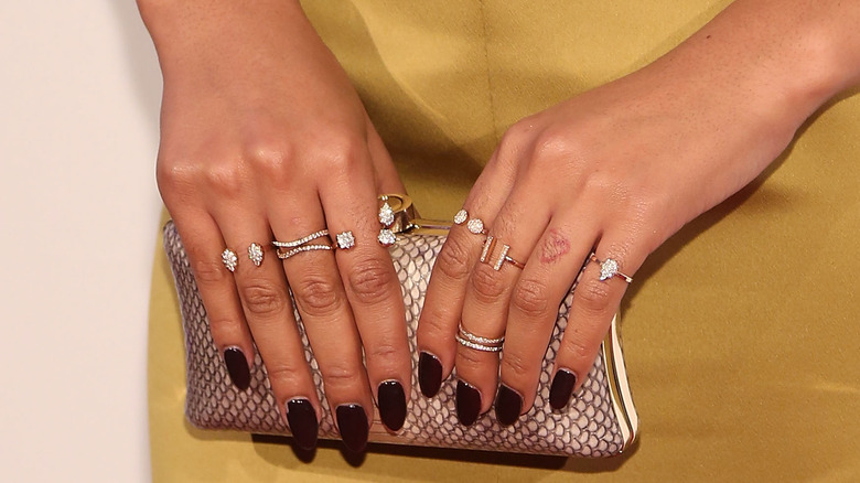 Chanel Iman's hands sporting various silver and diamond rings 