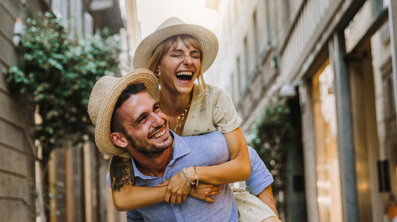 Woman on man's back laughing