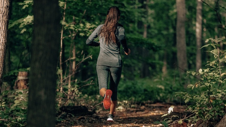 Woman running along a woodsy trail