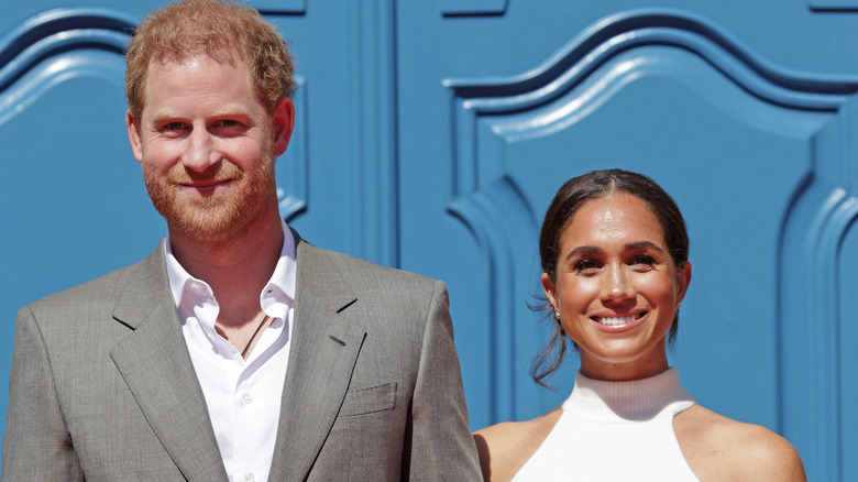 Prince Harry and Meghan Markle smiling blue doors