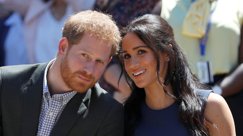 Meghan Markle leans in to tell Prince Harry something
